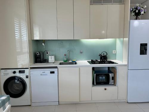里斯本YingYing Apartamento with a free parking space的厨房配有白色橱柜、洗衣机和烘干机