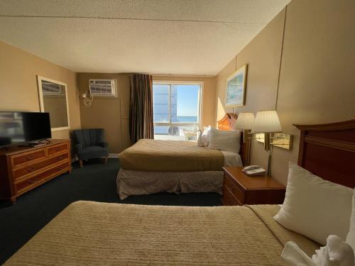 默特尔比奇Polynesian Oceanfront Hotel的酒店客房设有两张床和电视。