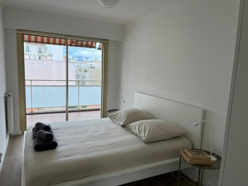 胡安莱潘Superbe T3 L’Illiade - Plages 3’ à pieds - Parking的一间卧室设有一张大床和大窗户