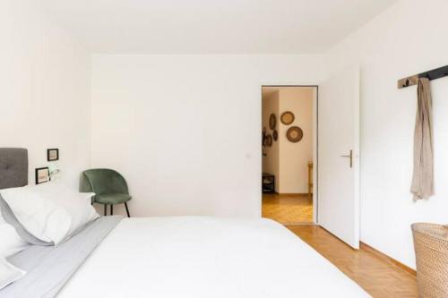洛桑Apartment of 52 sqm with free parking的卧室配有白色的床和绿色椅子