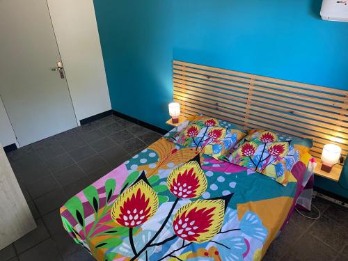 巴斯特尔Kazabasté, escapade spa et jardin privatif的一张带五颜六色的被子和鲜花的床