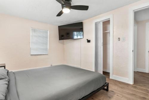 坦帕Westshore Stadium House的一间卧室配有一张床和吊扇
