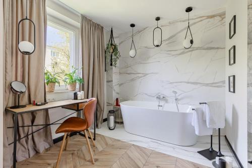 华沙Secret Garden Apartment的一间带白色浴缸的浴室和一张书桌