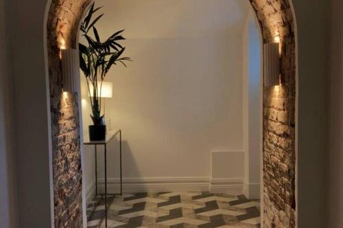 布莱克罗克Luxurious 2 bedroom apartment with sea view in Monkstown的走廊上设有拱门,种植了盆栽植物