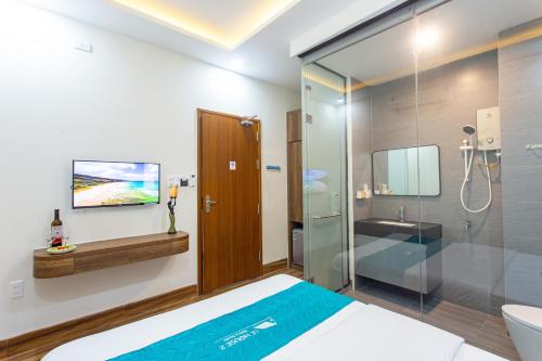 岘港Le House Hotel and Studio的浴室设有床铺和玻璃淋浴间。