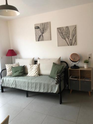 普罗普里亚诺T2 récent climatisé à 100m du port的客厅的沙发,墙上有两幅画