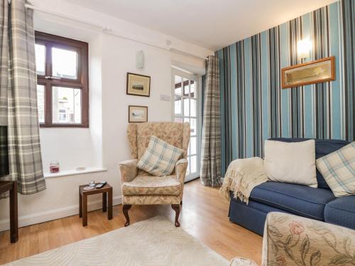 格兰奇奥沃桑茨Daffodil Cottage的客厅配有蓝色的沙发和椅子