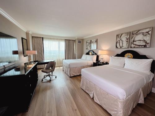 科默斯The Commerce Casino & Hotel的酒店客房配有两张床和一张书桌