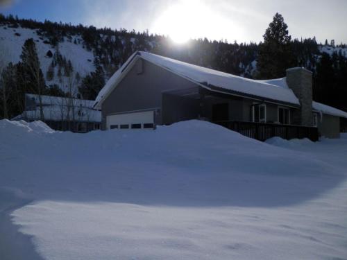 六月湖Elk House的雪覆盖的房子,后面有太阳