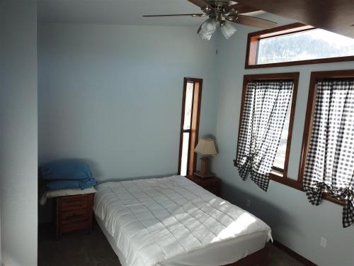 六月湖Rr-gull Lake Baby House的一间卧室配有一张床和吊扇
