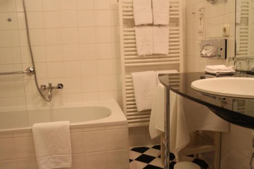 沃尔特湖畔韦尔登Hotel Seeschlößl Velden的白色的浴室设有水槽、浴缸和卫生间。