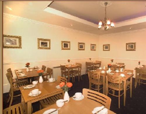 伦敦海德公园皮可里诺住宿加早餐旅馆的用餐室配有木桌和椅子