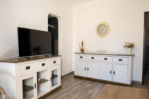 AlmádenaCasa Sabino的一间客厅,在白色的橱柜上配有电视