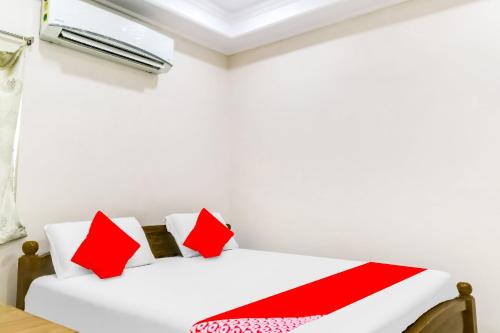 维沙卡帕特南OYO Flagship 81201 Sls Luxury Suites的配有红色和白色枕头的客房内的两张床
