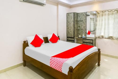 维沙卡帕特南OYO Flagship 81201 Sls Luxury Suites的一间卧室配有一张带红色枕头的大床