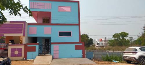 拉加蒙德里OYO HOME 81185 Srinivas Service Home的粉红色的蓝色房子