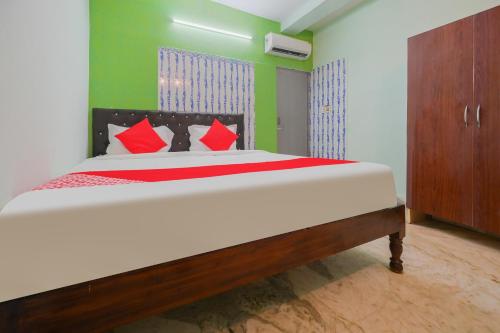 布巴内什瓦尔OYO Flagship 81152 Hotel Raz Stays的一间卧室配有一张带红色枕头的大床
