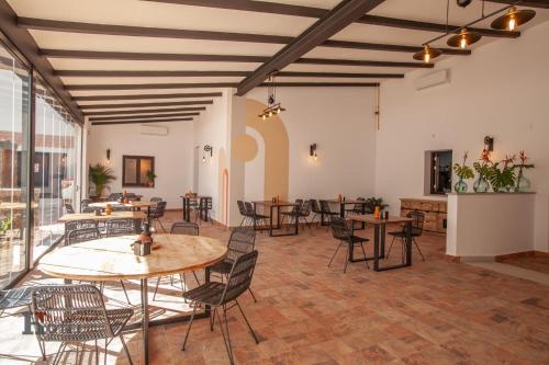 Hotel Rural el Turuñuelo的大型客房设有桌椅和窗户。
