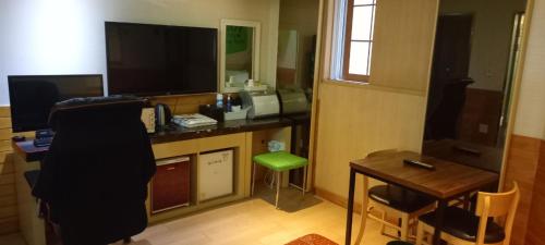 蔚山Design T Motel的客房设有一张桌子、一台电脑和一张绿色凳子