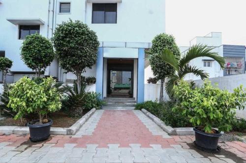 瓜廖尔OYO 81146 Hotel Prashant Villa的建筑前方有树木的砖砌走道