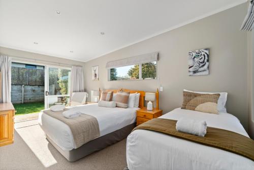 陶波The Lakehouse - Taupo的一间卧室设有两张床和窗户。