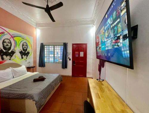 暹粒The Funky Village的一间卧室配有一张床和一台平面电视