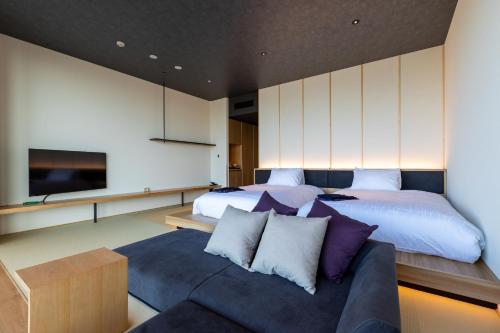 福冈The358 SORA的一间卧室配有一张床、一张沙发和一台电视。
