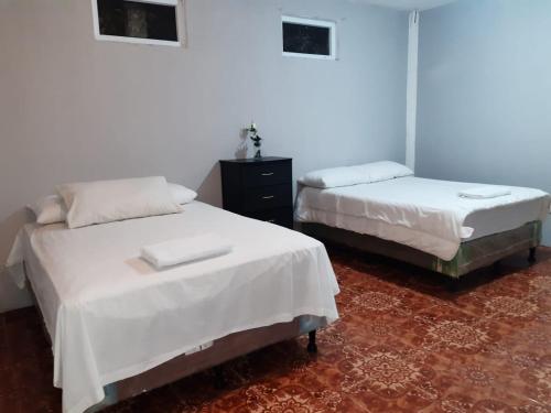 圣胡安拉拉古纳Casa Elenita的配有白色床单的客房内的两张床