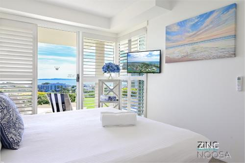 努萨角Crest Premium View Apartment 19的卧室设有一张白色大床和大窗户
