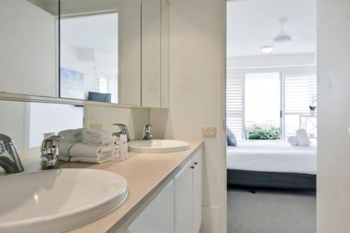努萨角Crest Premium View Apartment 19的白色的浴室设有2个水槽和1张床