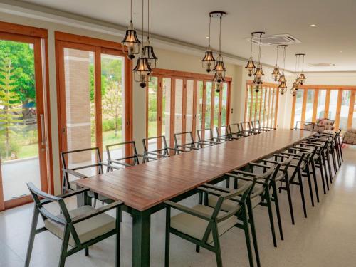 华欣Nichahome Luxury Villa的大型用餐室配有长桌和椅子