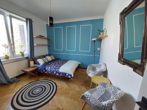 华沙Perfect location, cozy flat的一间卧室设有一张床和蓝色的墙壁