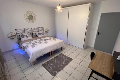 MontjolyAppartement T3 spacieux的一间卧室配有一张床、一张桌子和一张桌子。