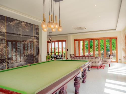 华欣Nichahome Luxury Villa的客厅设有台球桌,客厅设有游泳池