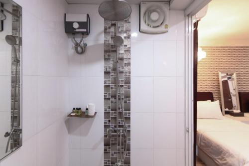 曼谷Sweetloft Hotel Don Muang的带淋浴的浴室和客房内的一张床