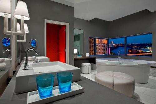 奥斯汀奥斯丁W酒店的带浴缸、水槽和两杯眼镜的浴室