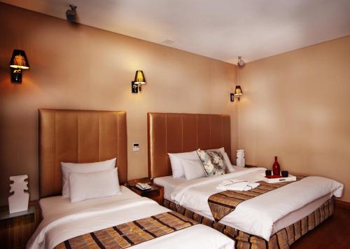 富川市北极星酒店的酒店客房,设有两张床,墙上有灯