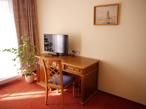 费茨肖Garni-Hotel zum alten Ratskeller的一张桌子,电视机和椅子放在房间里
