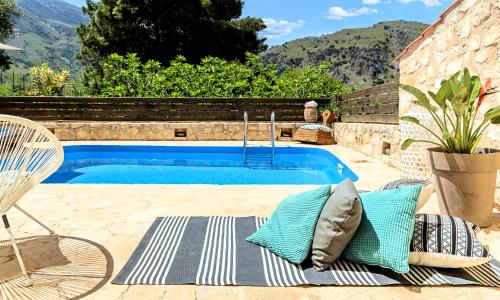 MouríonApple Villas的游泳池旁配有枕头和椅子