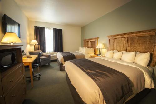 BabbittJunction Inn Suites & Conference Center的酒店客房设有两张床和电视。
