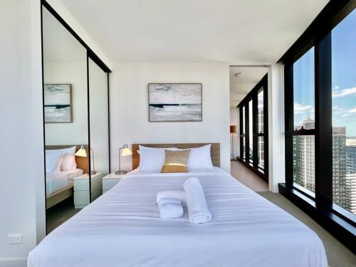 墨尔本Highrise best location 2baths的卧室设有一张大白色的床和大窗户