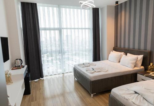 伊斯坦布尔The Hera Maltepe Otel & Spa的酒店客房设有一张床和一个大窗户