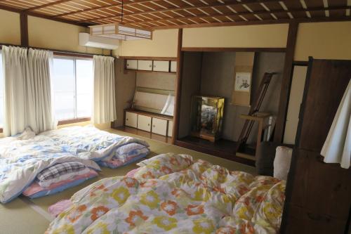 KitsukiCastle town private Inn ONE WORLD的一间卧室设有两张床和窗户。