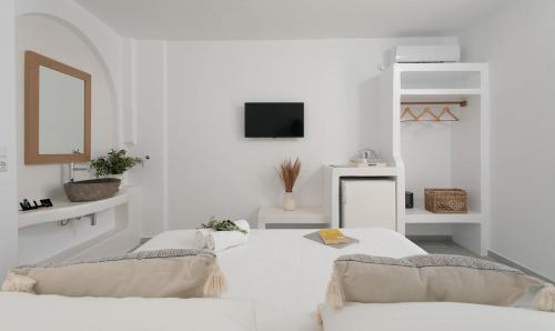 纳克索乔拉伊珀卡姆珀斯海滨公寓的白色的客房配有两张床和电视。