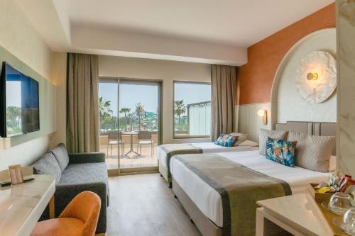 拉瑞拉拉成名公寓酒店及Spa的酒店客房,设有两张床和一张沙发