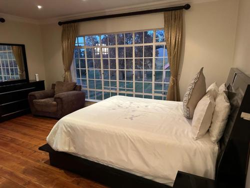 克拉伦斯Thula Guest Farm的一间卧室设有一张床和一个大窗户