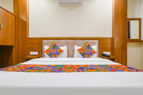 印多尔FabHotel Atharv的一间卧室配有一张带五颜六色棉被的床