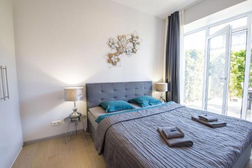 尤尔马拉New apartment LOFT MAJORI with terrace的一间卧室配有一张带蓝色枕头的床和一扇窗户。