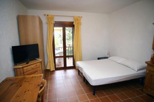 罗萨岛迪默黛尔伊索拉罗萨公寓的一间卧室配有一张床和一台平面电视