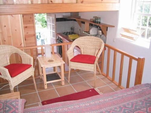 Faja Grande干草堆乡村民宿的客厅配有两把椅子和一张桌子